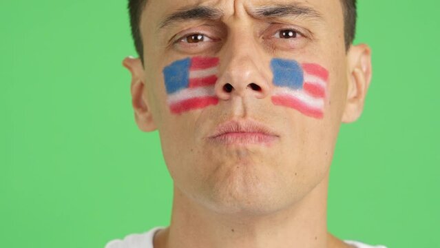 Serious man with a USA flag painted on the face