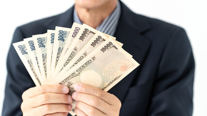 スーツ姿でお金を持つ男性