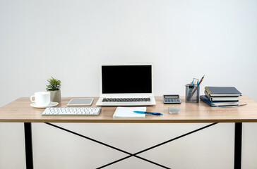 Empty notepad with pen laptop calculator coffee on a office wooden surface, nobody.