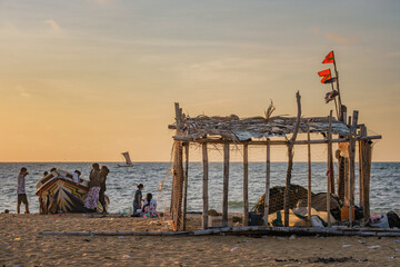 Fisherman's hut with fishnets on the Negombo main beach in Sri Lanka with a family hanging around...