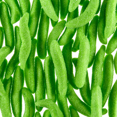Texture of randomly scattered gelatin candies made in the form of green pea pods sprinkled with sugar. - 655613755