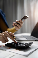 Hand business woman doing finances and calculate on desk about cost at office.