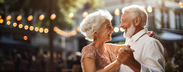 Happy seniros couple dance and smile in the garden.