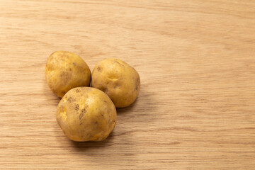 木の板に置いた３個のじゃがいも「左空き」