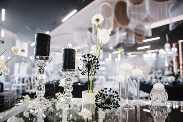 Trendy black rich decor. Banquet decoration composition flowers, candles, candlesticks in hall restaurant. Luxury wedding reception. Table setting, setup. Birthday, baptism, event. Details interior.