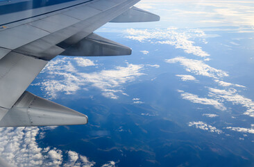 Aerial view of clouds over mountains. Airplane flight from Seattle to Anchorage. Alaska.