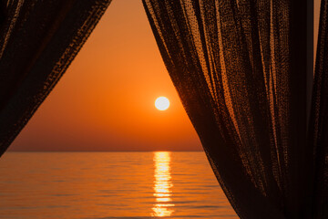sunrise behind curtains in resort