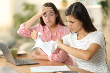 Angry worker breaking contract beside her worried colleague