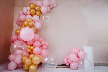 Arch with balloons for party. Beige photo wall decoration space or place with pink, golden balloons. Trendy spring decor. Celebration concept. Birthday party. Wedding reception with a table for cake.