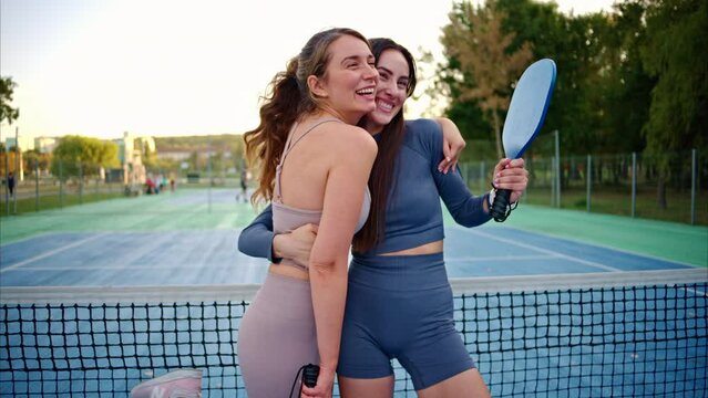 Women hugging and celebrating success at pickleball match