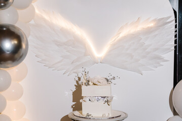 Arch decorated white, silver balloons, angel wings. Trendy baptism cake with figure newborn, decor...