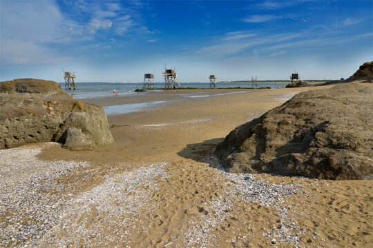 Beach and fishing carrelets from Saint-Michel-Chef-Chef at low tide and the town of Saint Nazaire in the background in Pays de la Loire region in western France