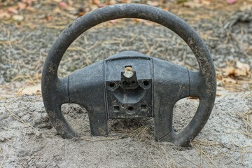 Automobile old discarded dirty black rubber industrial broken round modern steering wheel lies in...