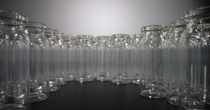 Many glass vials and laboratory equipment for dispensing liquid samples. Professional glassware for medical purposes and laboratory research