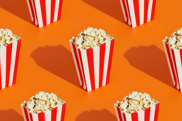 Striped boxes with popcorn on an orange background