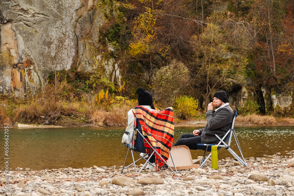 Poster happy couple having picnic at river beach