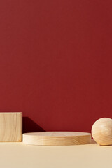 Wooden scenes of different geometric shapes on a beige table on a red wall. Premium podium for...