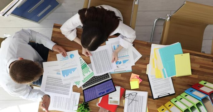 Male boss showing fellow marketer errors in documents in office top view. Error in report concept and angry manager