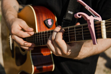 Playing guitar. Hands and strings of a guitar. A man plays the guitar.