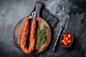 Traditional spanish Chorizo sausage, dry cured pork meat. Black background. Top view - obrazy, fototapety, plakaty