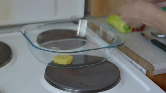Static, close up shot of a woman placing potatoes in a baking tray. Panasonic Lumix S5 with a 75mm lens.