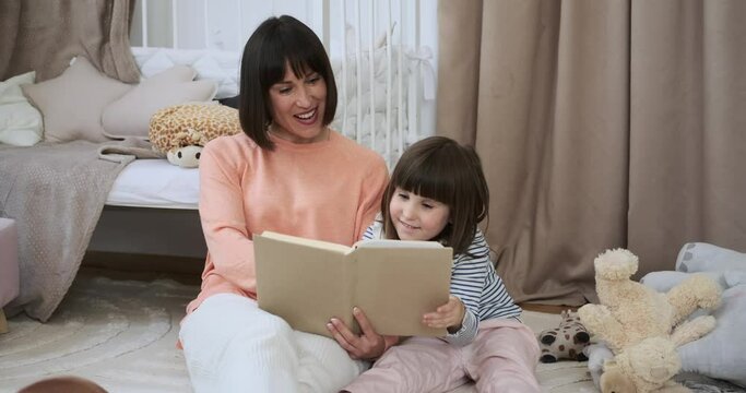 In the enchanting child room, a mother and daughter are completely absorbed in the joy of reading a book together while sitting on the floor. Their shared literary adventure creates a beautiful scene.