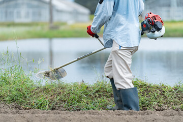 草刈りをする日本人男性