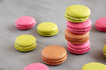Colorful Homemade French Macarons on gray background, side view.