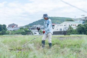 草刈りをする日本人男性