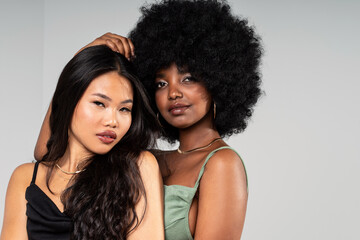 Multiethnic two women with different skin types posing together, looking at the camera. Beauty...