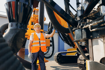 Hydraulic engineer doing safety check on new installation hoses of modern drilling industrial machine. Concept industry work