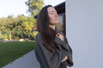 Fototapeta premium Woman relaxing in the morning in sunlight next to her house