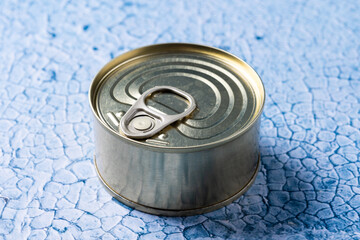 Canned food in metal can on blue background