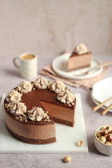 No-bake Nutella cheesecake with chocolate ganache and hazelnuts on a white plate