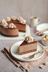 No-bake Nutella cheesecake with chocolate ganache and hazelnuts on a white plate