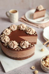 No-bake Nutella cheesecake with chocolate ganache and hazelnuts on a white plate