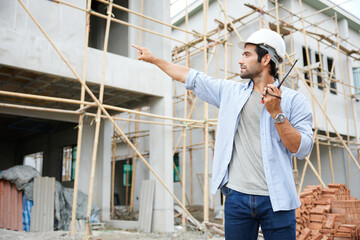 Fototapeta na wymiar worker or architect using walkie talkie and talking to someone at construction site