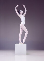 Like a porcelain statue. Elegant, beautiful woman, ballerina posing on cube over studio background. Concept of classical art, beauty, elegance, classical dance, talent and hobby. Ad