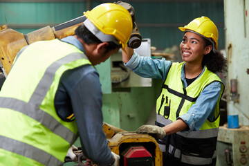 worker or engineer checking and fixing a machine with coworker in the factory