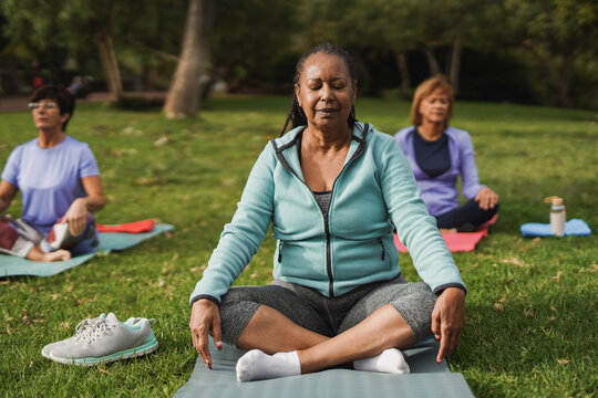 Multiracial senior women doing yoga exercise at city park - Mental health and fit elderly people concept
