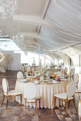 Luxurious restaurant. Luxurious interior, white tables, serving dishes and glasses for guests