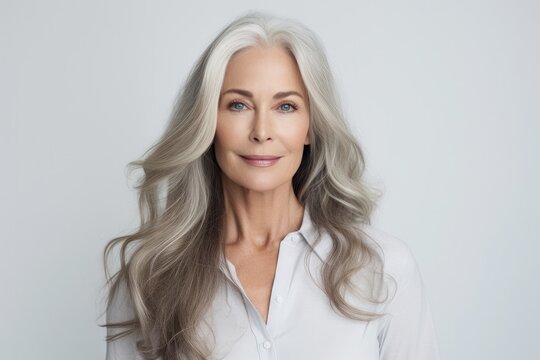A senior Caucasian woman with elegant gray hair, exuding confidence and natural beauty in a portrait
