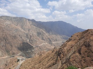 A beautiful view of the mountain road of Al Bahah, Saudi Arabia during the day. This road goes up high between high mountains.