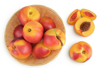 Ripe nectarine fruit with half in a wicker basket isolated on white background with full depth of field. Top view. Flat lay