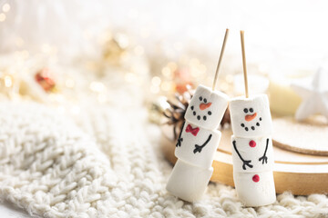 Winter composition with a cup of cocoa and marshmallows on a blurred background.