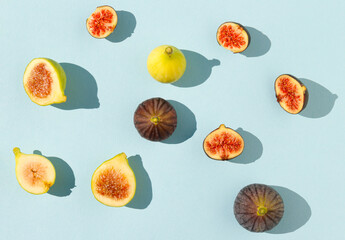 Pattern scene with yellow and black figs on sunny day. Minimal arrangement on blue background. Flat...