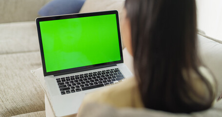 Anonymous Young Female Doing Creative Work on a Laptop Computer with Green Screen Mock Up Display....