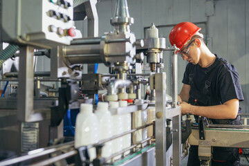 Production line worker or technologist in uniform working in chemical industry and checking quality...