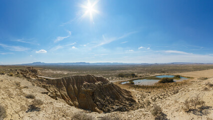 Desert landscape of the arid plateau of the Bardenas Reales with small lake at Mirador de Juan...