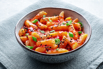 Tteokbokki or topokki, Korean street food, spicy rice cakes in red pepper gochujang sauce, a popular dish in a cafe